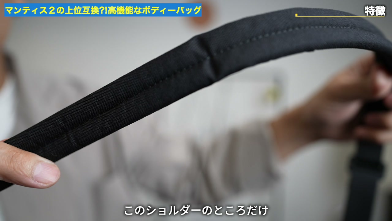 ショルダーストラップのクッション部分を手で示しているシーン