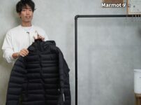 マーモット 1000フィルパワーダウンジャケットを手に持って紹介するたくぞーさん